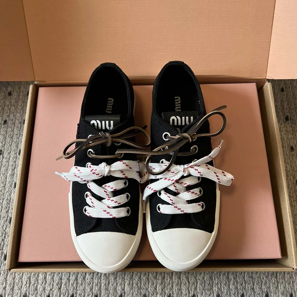 Close-up of black washed denim fabric and lace detail on sneakers