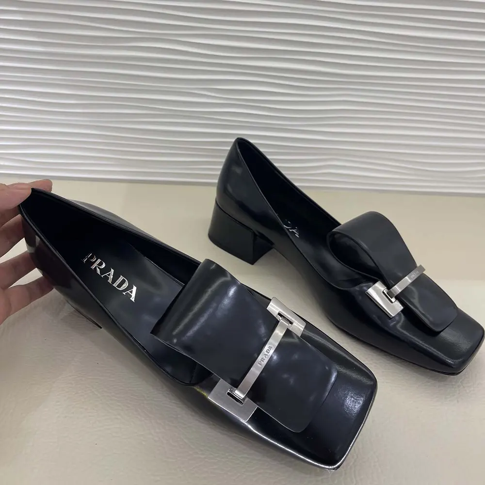 Top angle highlighting signature Prada embossed detail on black pumps