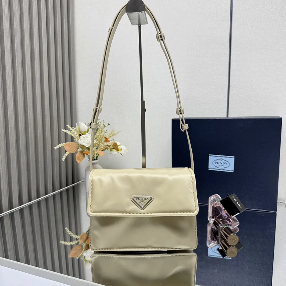 Close-up of silver Prada logo hardware on beige shoulder bag