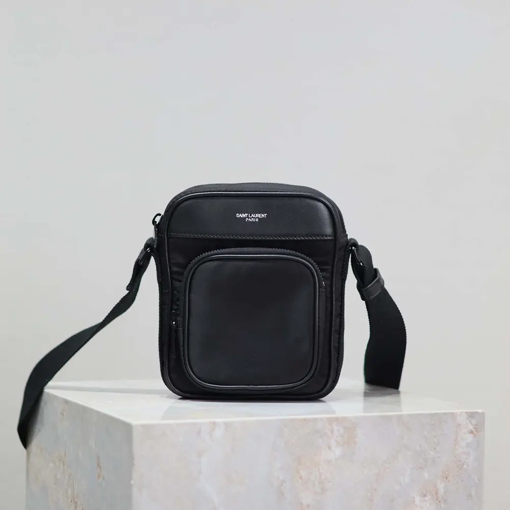 Close-up of polished YSL logo hardware on nylon mini camera bag