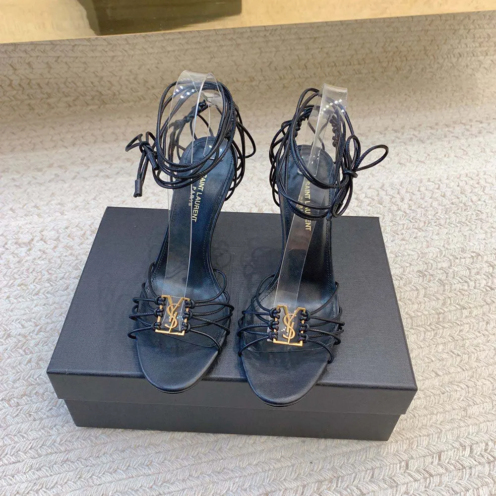 Close-up of gold YSL logo detail on Babylone Sandals by Saint Laurent