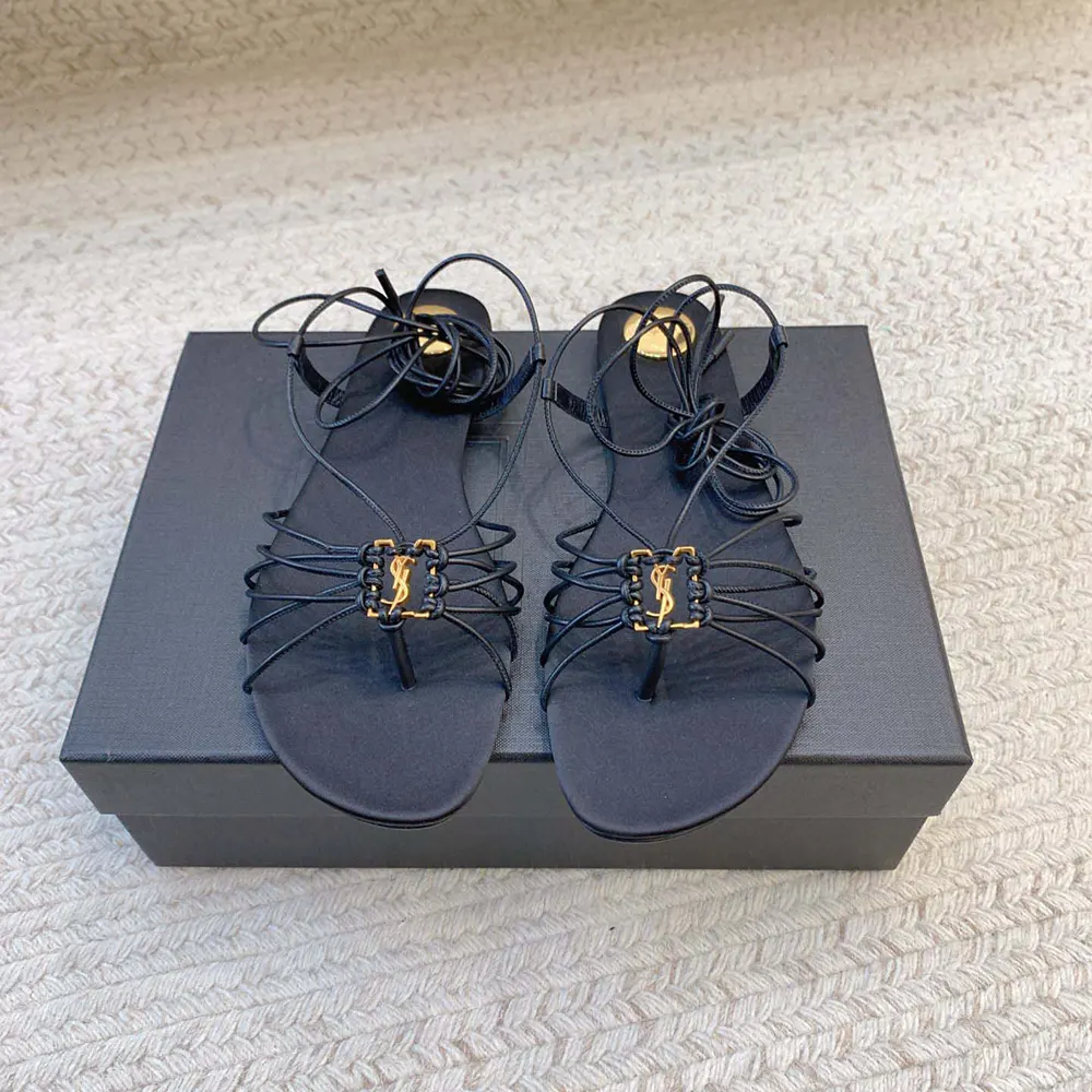 Close-up of gold YSL logo hardware on Babylone Sandals black leather strap