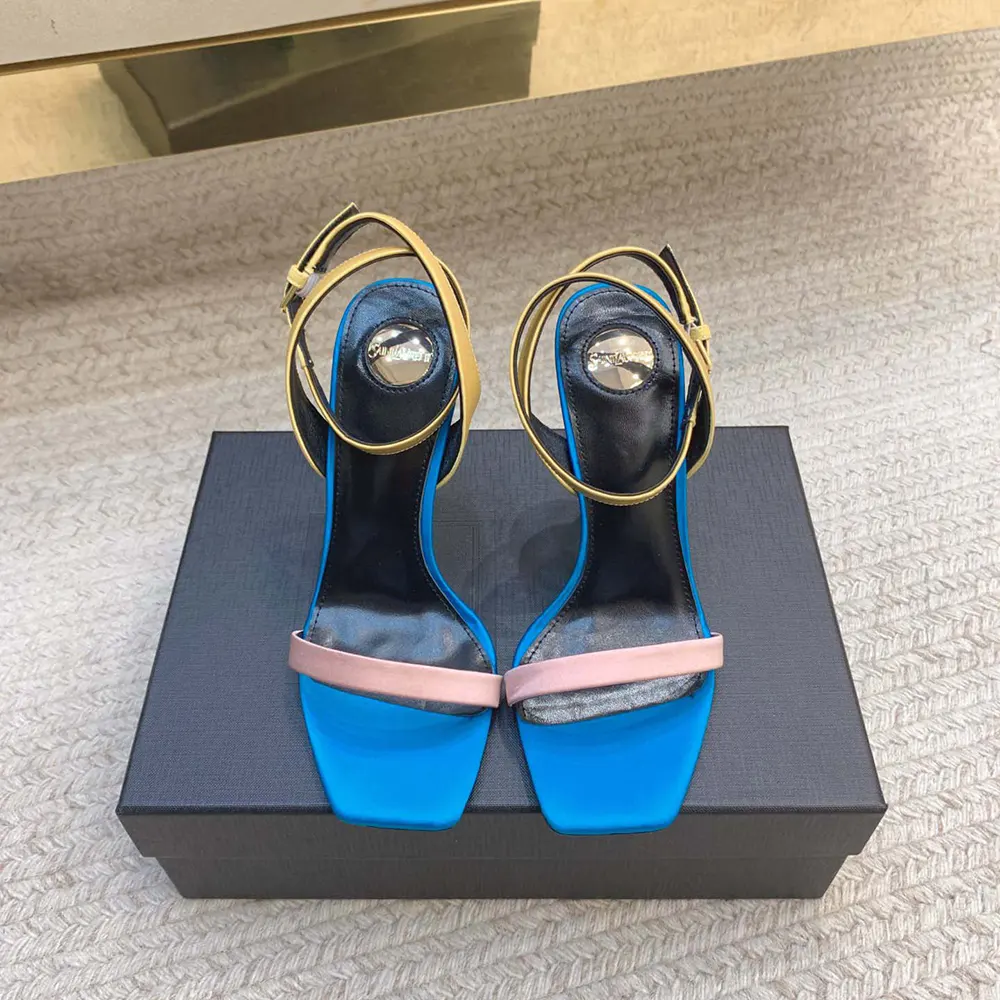 Close-up of gold YSL logo hardware on Dominique Sandals satin crepe