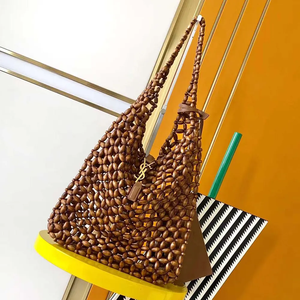 Close-up of gold-tone YSL hardware on brown wood bead bag