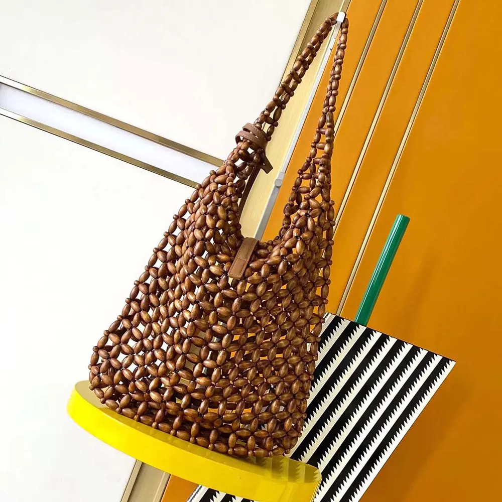 Side angle showing silhouette of Saint Laurent wood bead shoulder bag