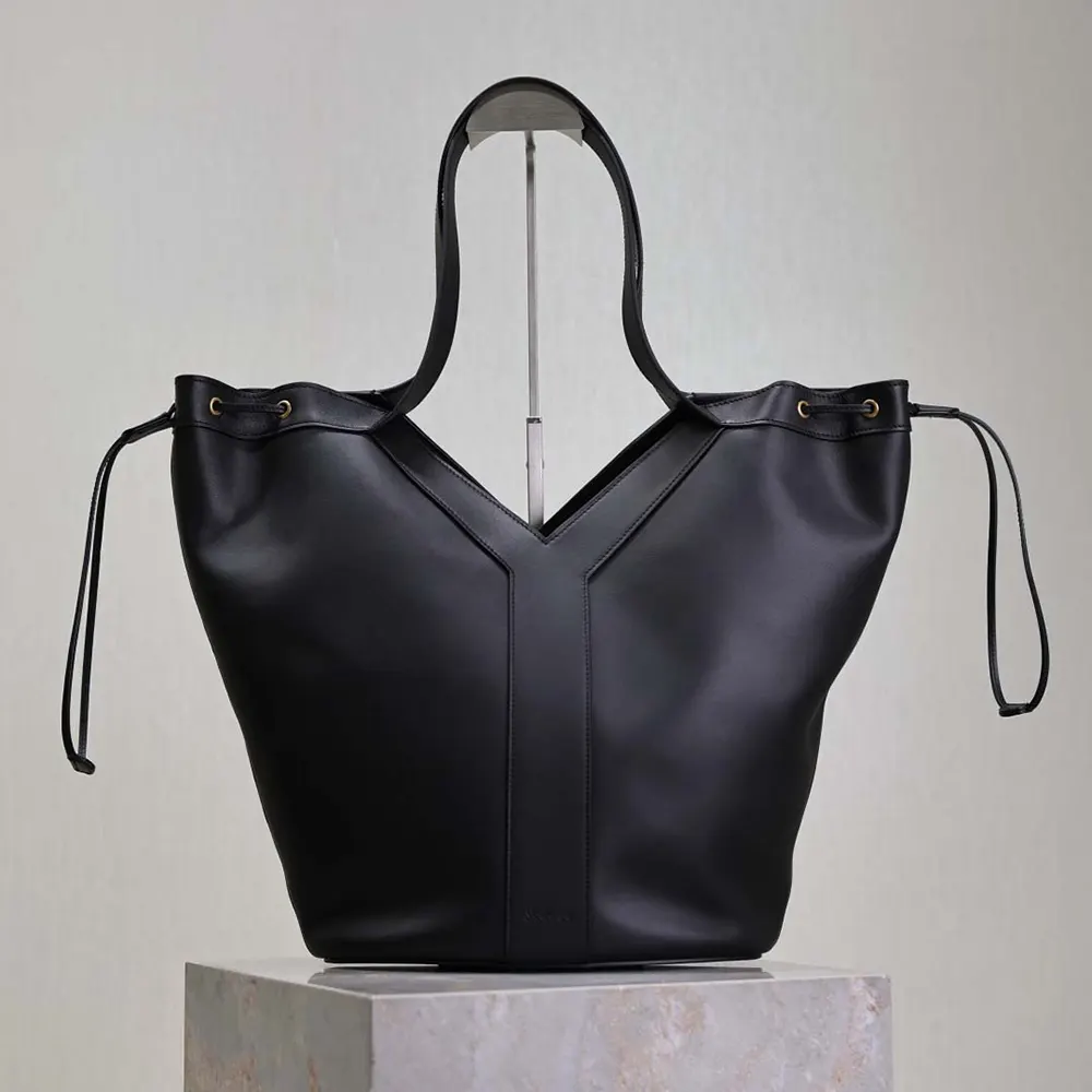 Close-up of gold YSL logo hardware on black leather hobo bag