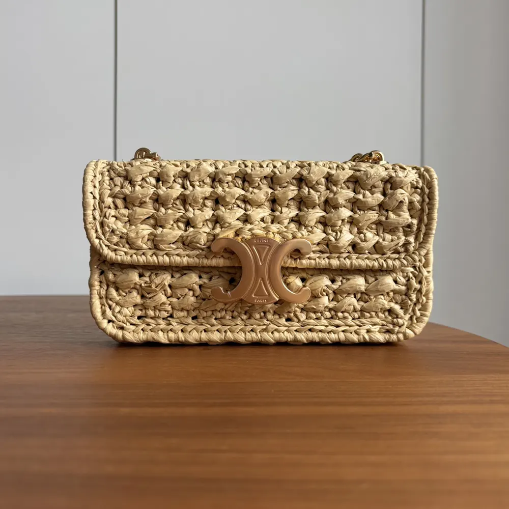 Close-up of gold chain and natural raffia effect on Celine Claude bag