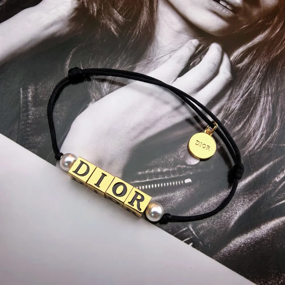 Side view of Dior Women D-Dice Bracelet showing gold-finish metal and pearls