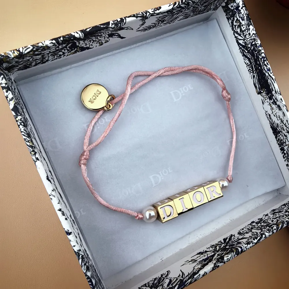 Side angle of Dior Women D-Dice Bracelet highlighting pale pink cotton details
