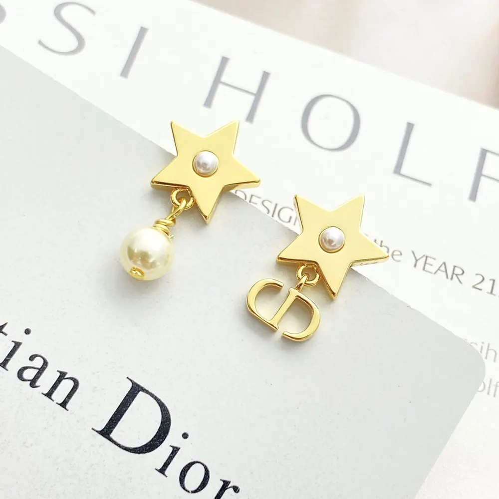 Detail of engraved Lucky Dior signature on gold-finish earrings