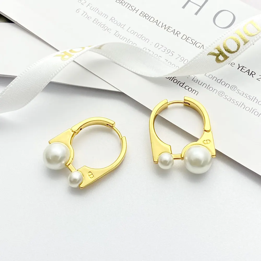 Close-up on signature double-sided design of Dior Women Medium Dior Tribales Earrings