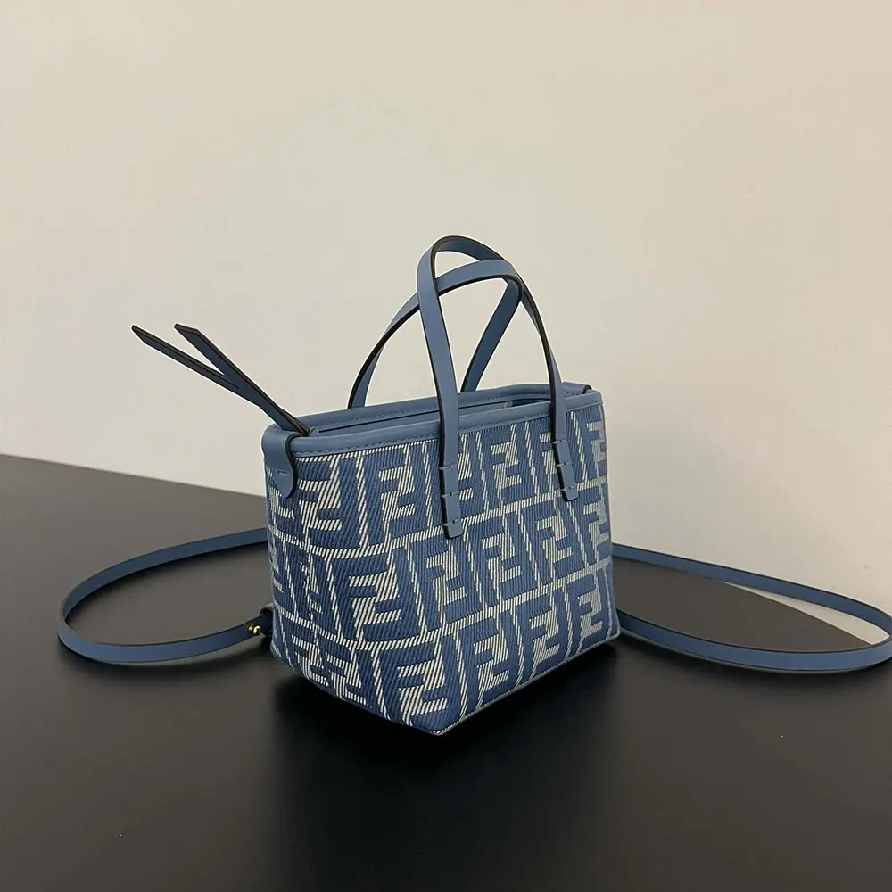 Side profile showcasing flap closure of Fendi Women Roll Mini Blue Denim-effect bag