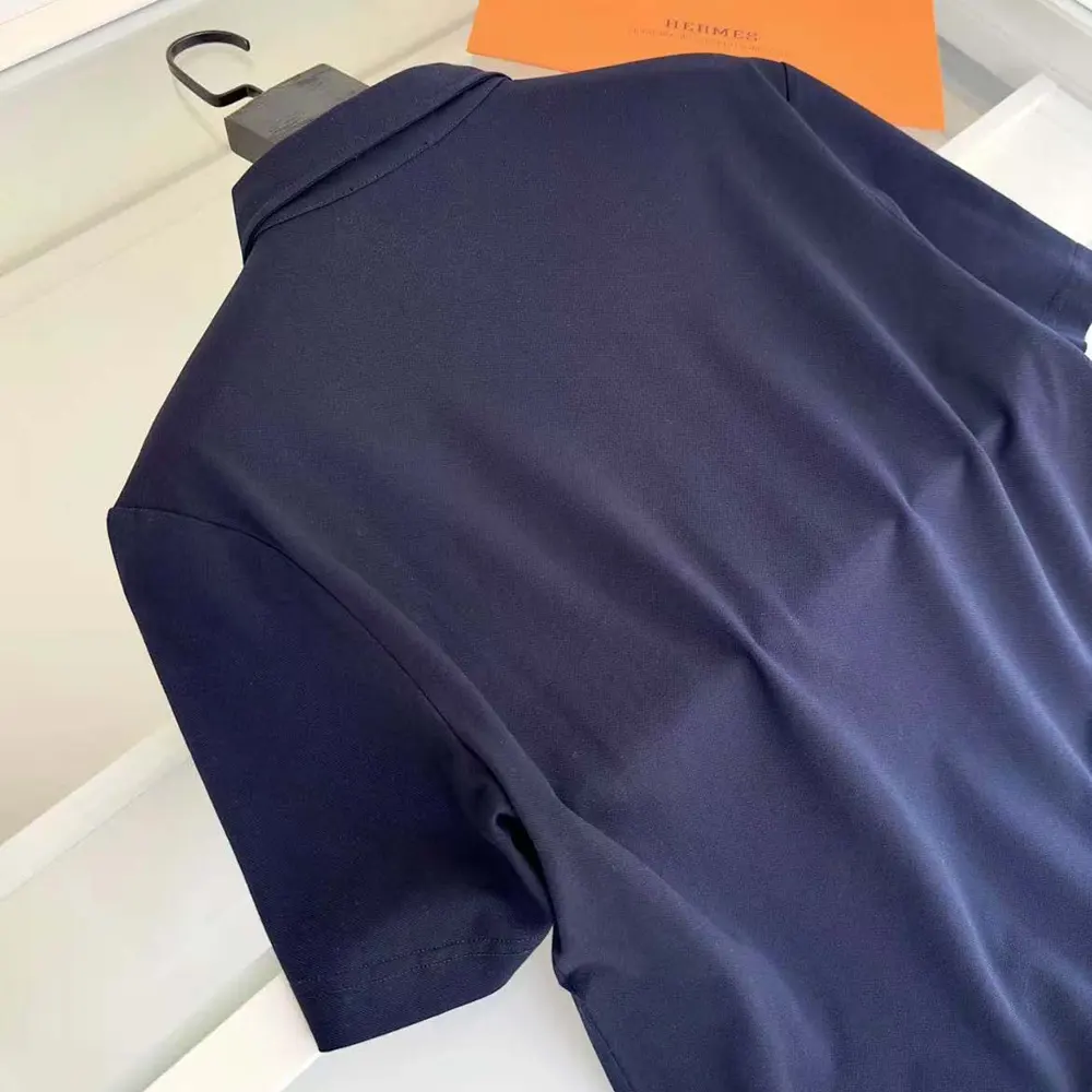 Side angle of Hermes Men Polo Shirt with Pocket-Navy/Brown highlighting sleeve and silhouette