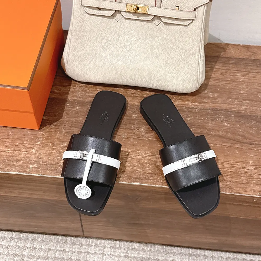 Close-up of Hermes hardware on Hermes Unisex Giulia sandal-Black/White