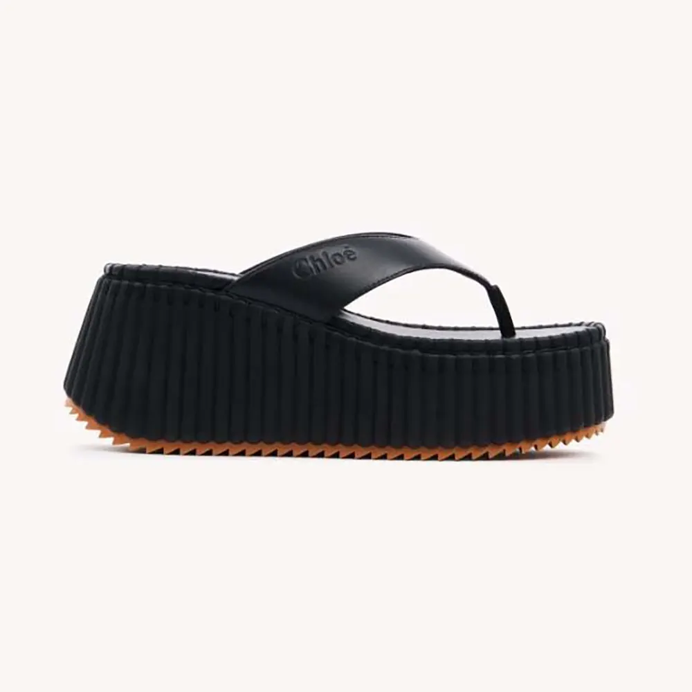 Front angle of Chloe Women Nama Wedge Slide-Black showing leather upper