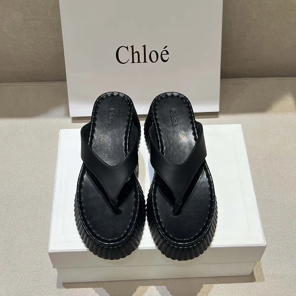 Side profile of Chloe Women Nama Wedge Slide-Black highlighting wedge heel