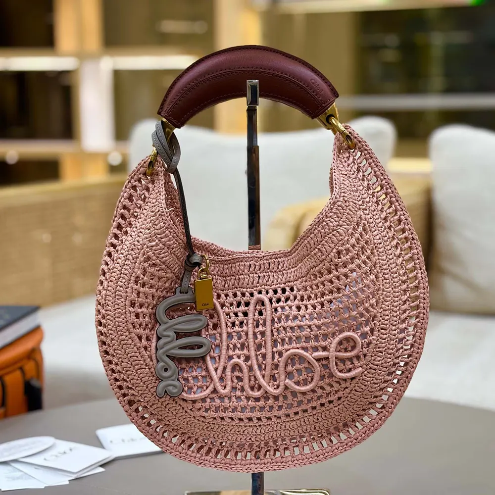 Close-up of pink raffia texture and gold hardware on Chloe hobo bag