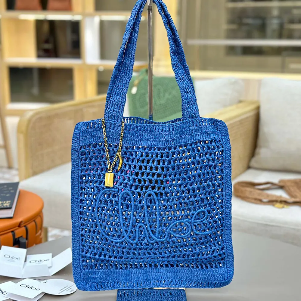 Close-up of blue leather trim and gold-tone hardware on tote bag