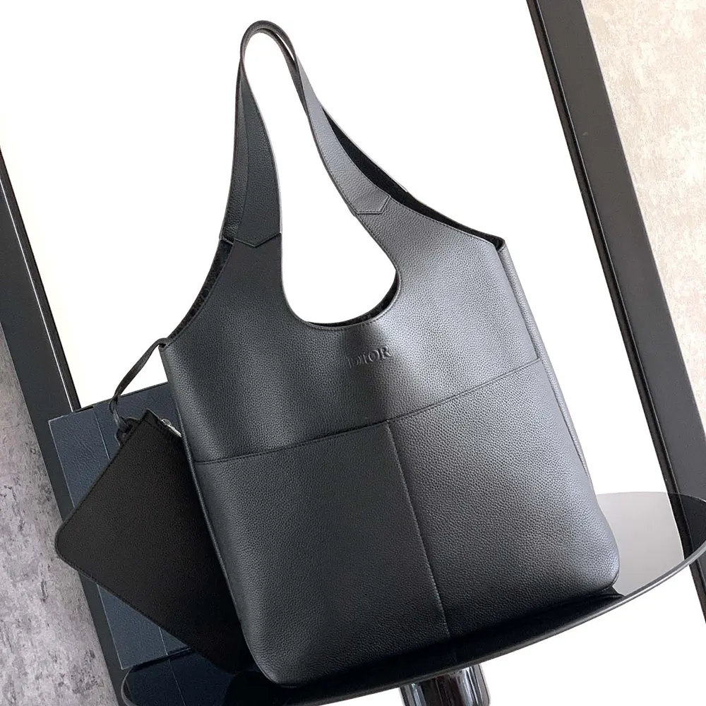 Close-up of black calfskin texture and Dior icons hardware on tote