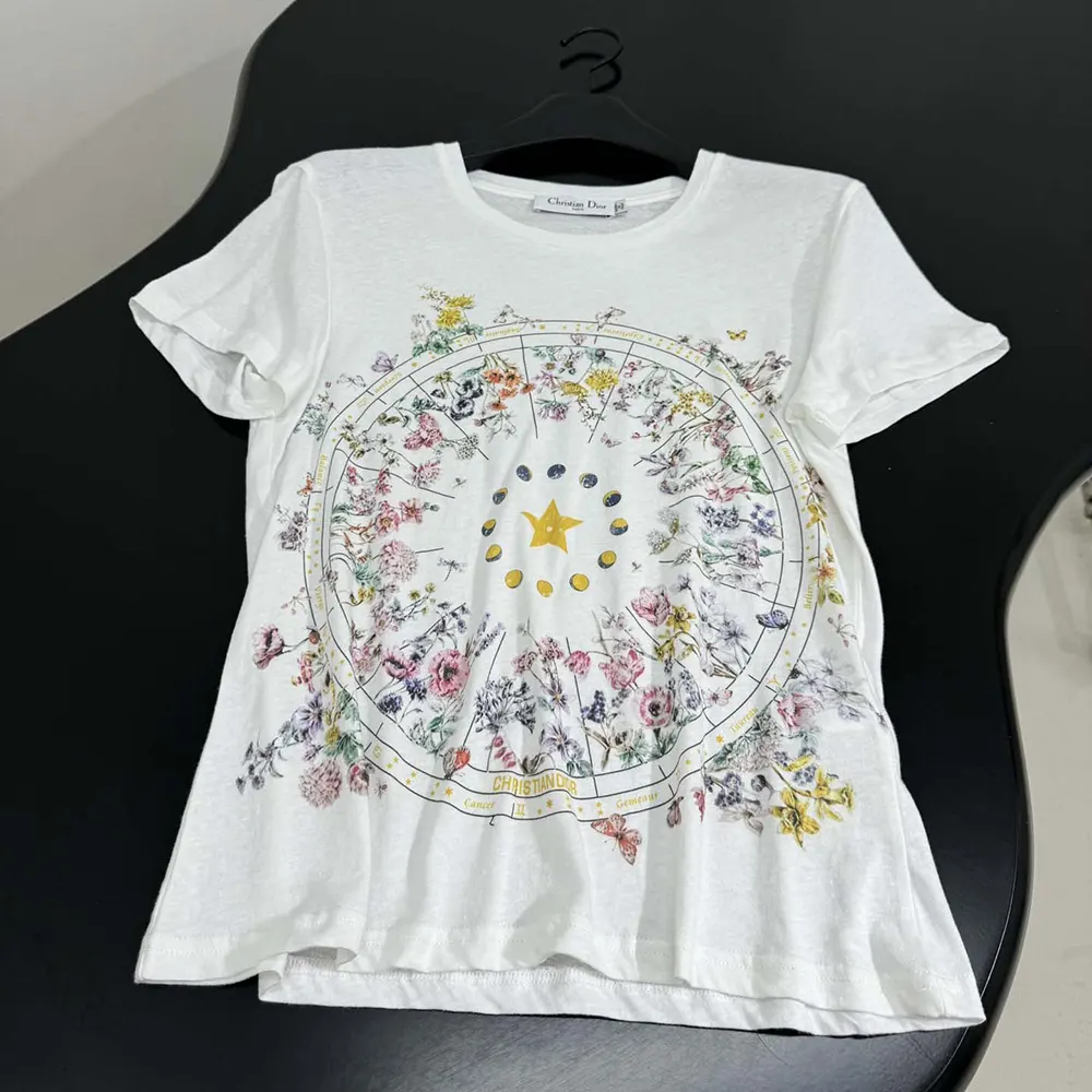 Close-up of multicolor Dior Astral Flowers motif on white cotton jersey tee