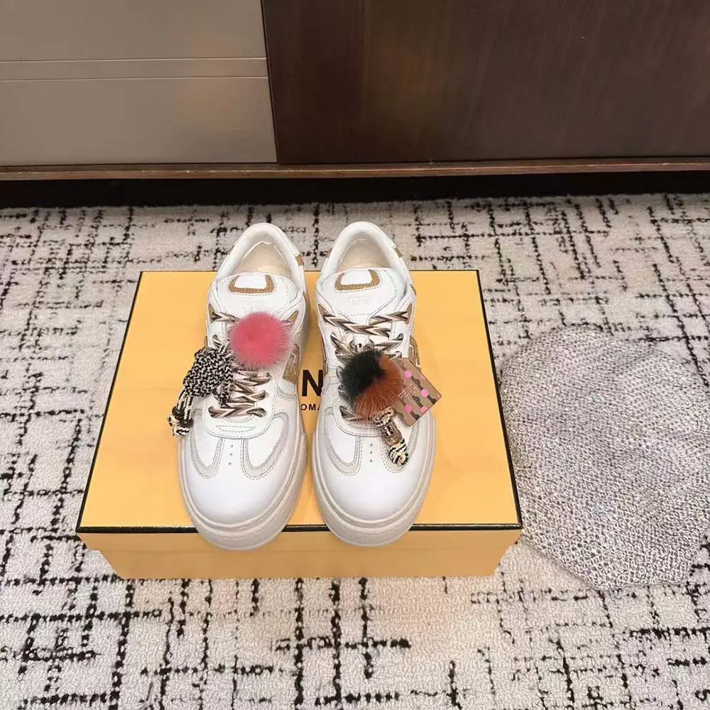 Close-up on gold-tone charm detail of Fendi Women Match Low Top Platform Shoes
