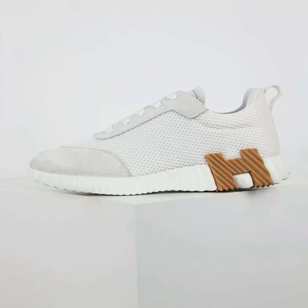 Close-up on graphic mesh and embossed Hermes logo hardware detail