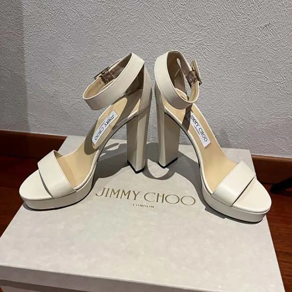 Close-up of white leather and gold buckle on Jimmy Choo Isra sandals