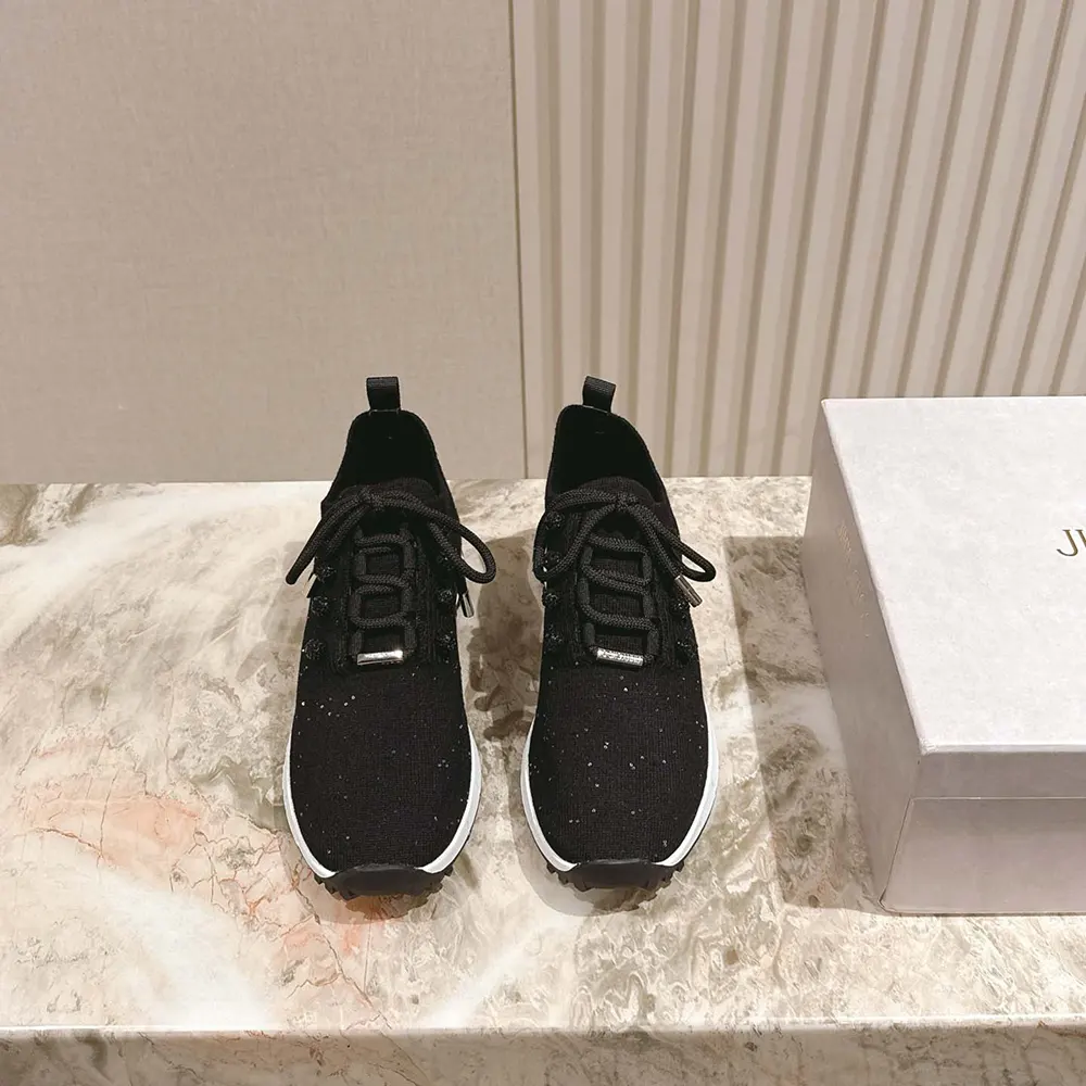 Close-up detail of black sequin knit and silver logo on Jimmy Choo trainers