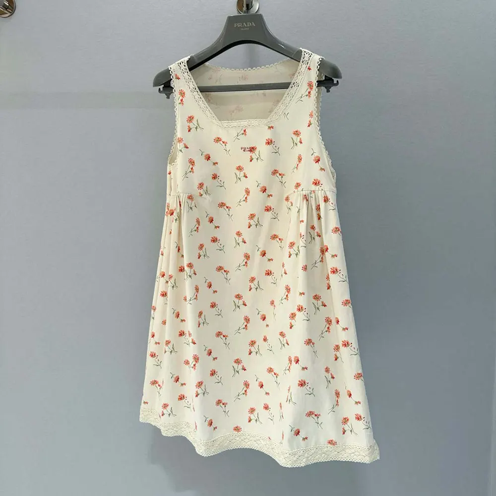 Close-up of floral print and Prada logo plaque on mini-dress