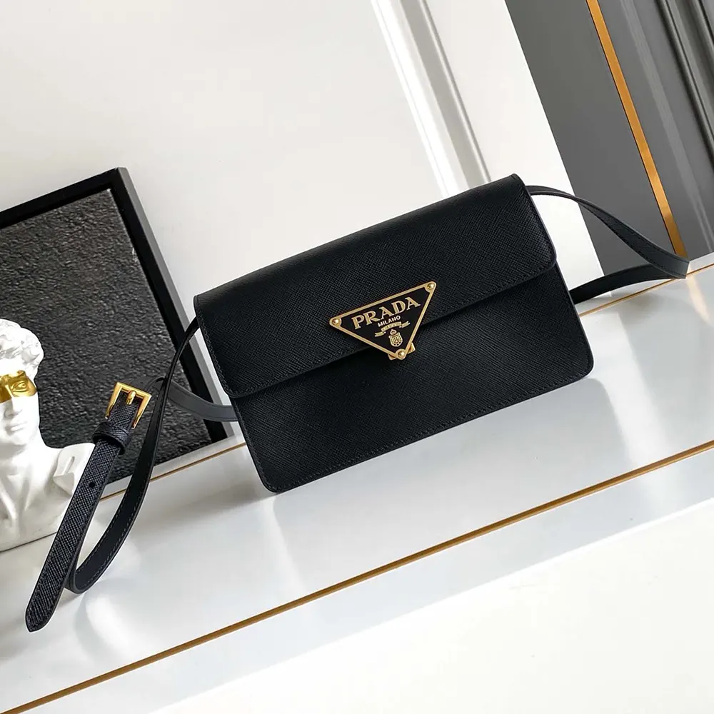 Close-up of gold-tone Prada logo on mini-bag leather surface