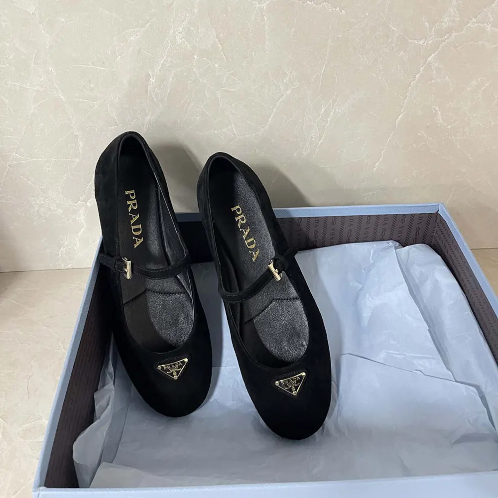 Top-down view highlighting Prada logo hardware on black ballerinas