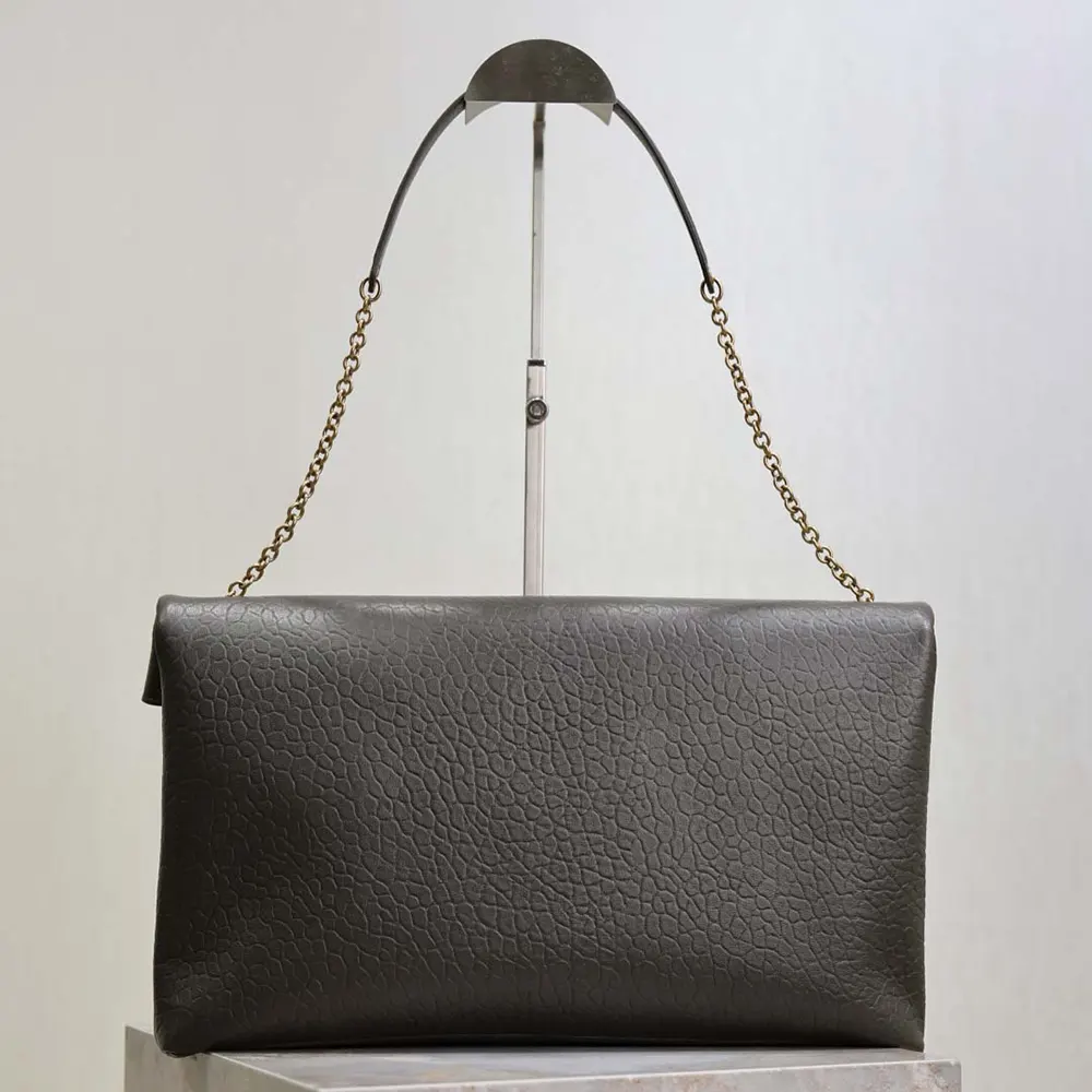 Side angle showing chain strap and envelope silhouette of Saint Laurent pouch