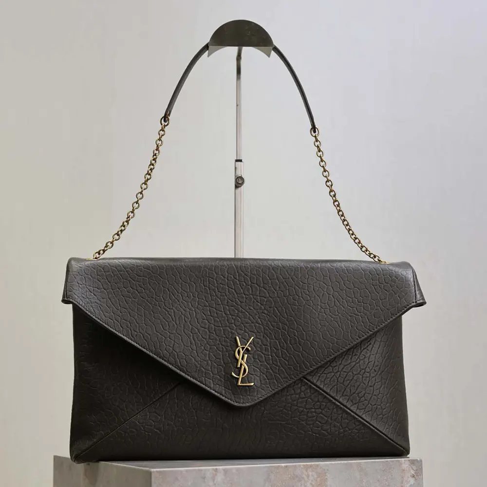 Close-up of antique gold YSL logo hardware on Cassandre XXL Envelope Pouch