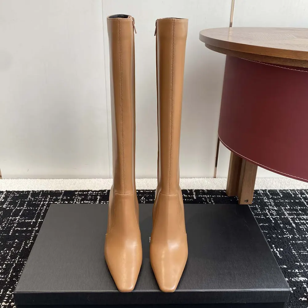 Close-up of gold YSL hardware on brown leather Francoise boots