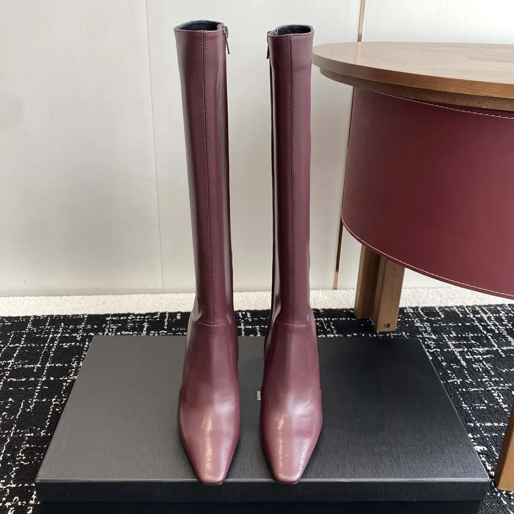 Close-up of gold YSL logo hardware on maroon Francoise Boots
