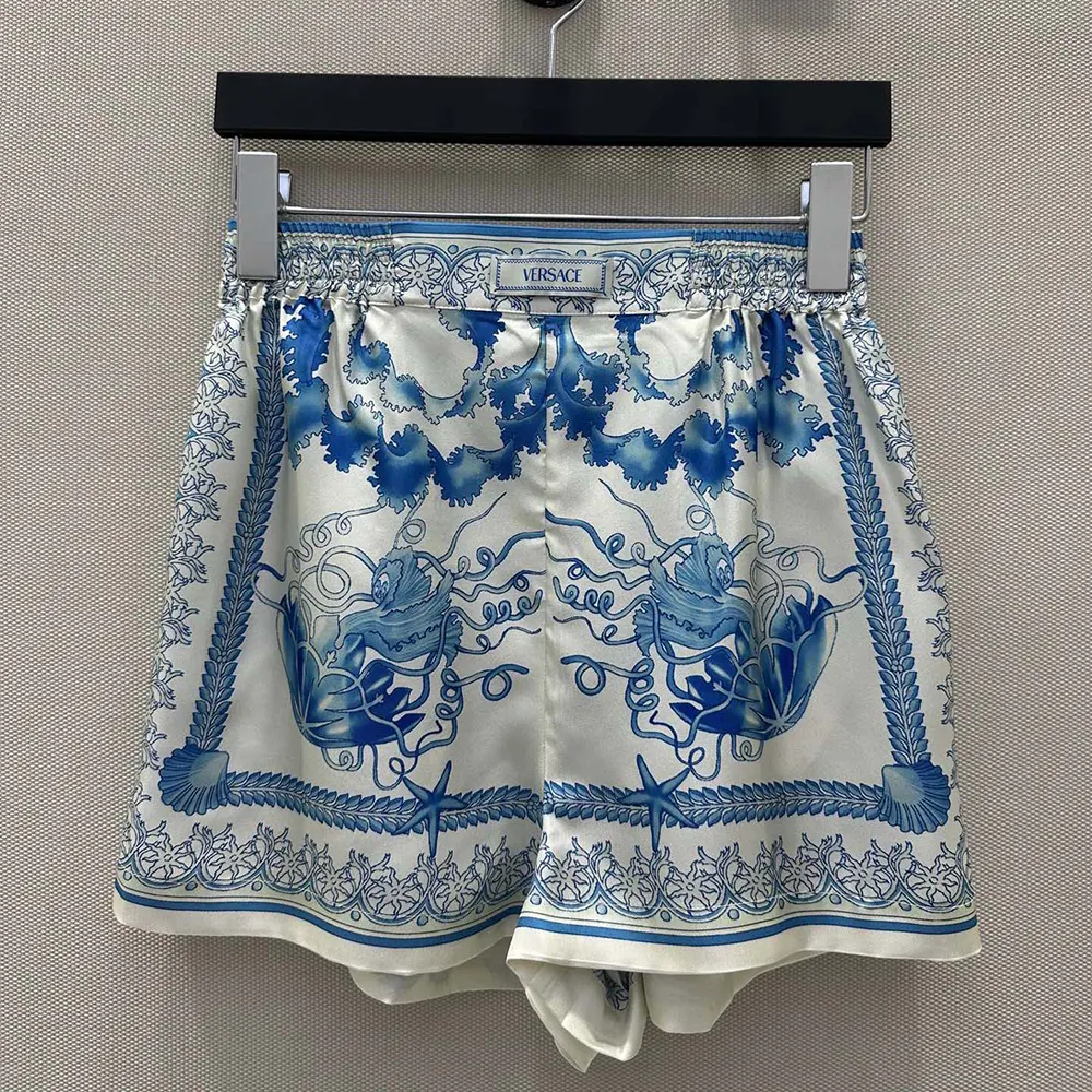 Close-up of gold Medusa hardware on Versace Women Underwater Barocco Cotton Shorts-Blue