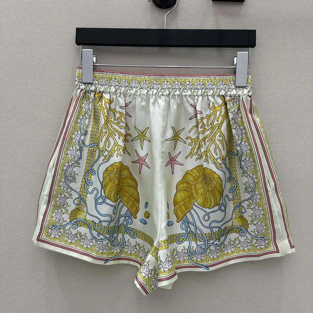 Side angle showing Medusa hardware on Versace silk shorts