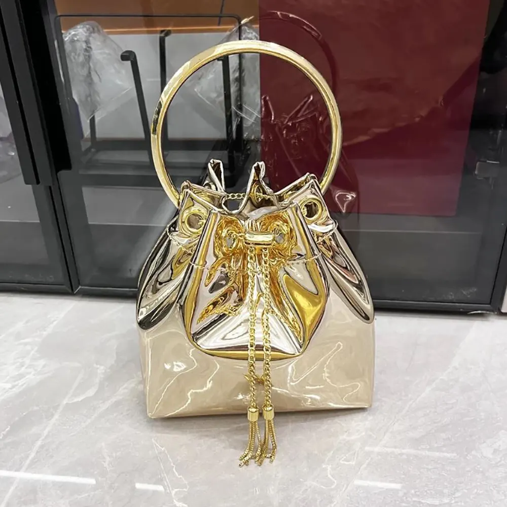Close-up of gold mirror fabric texture and metal handle on Jimmy Choo Bon Bon mini bag