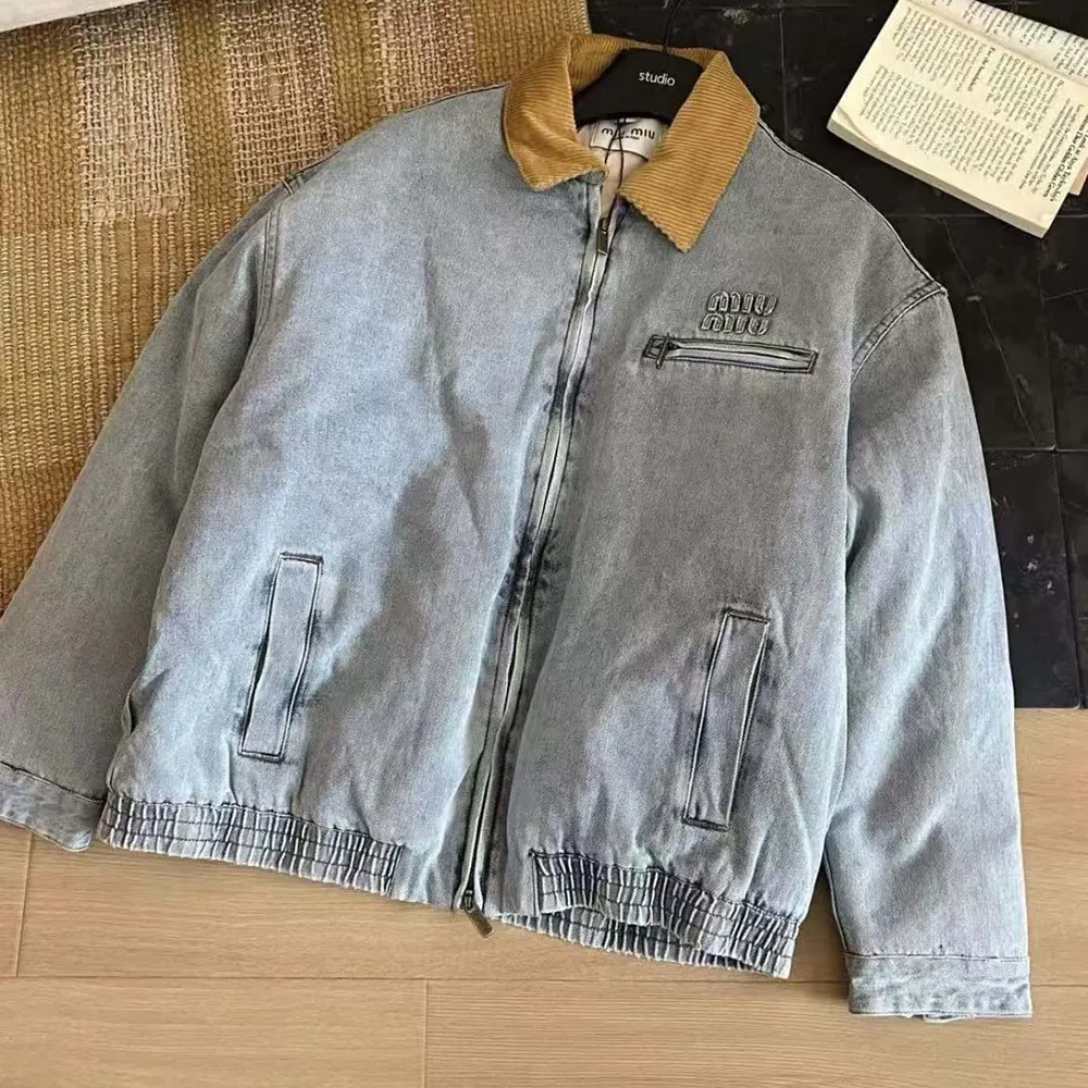 Close-up of logo embroidery and metal buttons on denim blouson