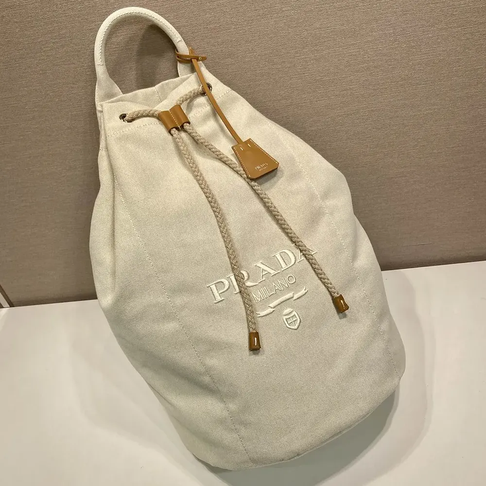 Side angle showing compact silhouette of Prada Linen Blend Duffel Bag