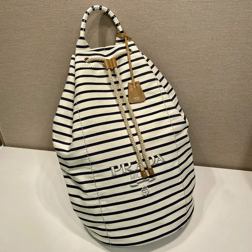 Side view showing polished hardware on Prada Unisex Striped Canvas Duffel