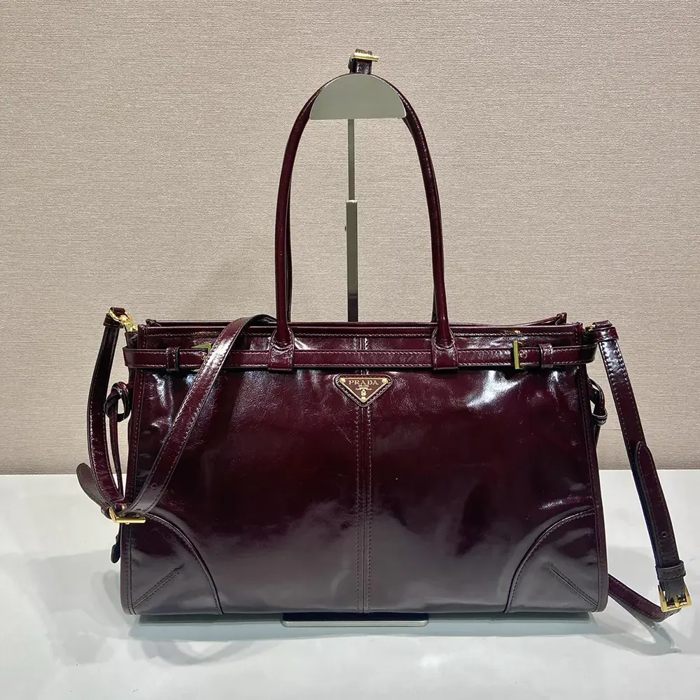 Close-up of gold-tone hardware on Prada Women Bonnie Medium Leather Handbag-Maroon