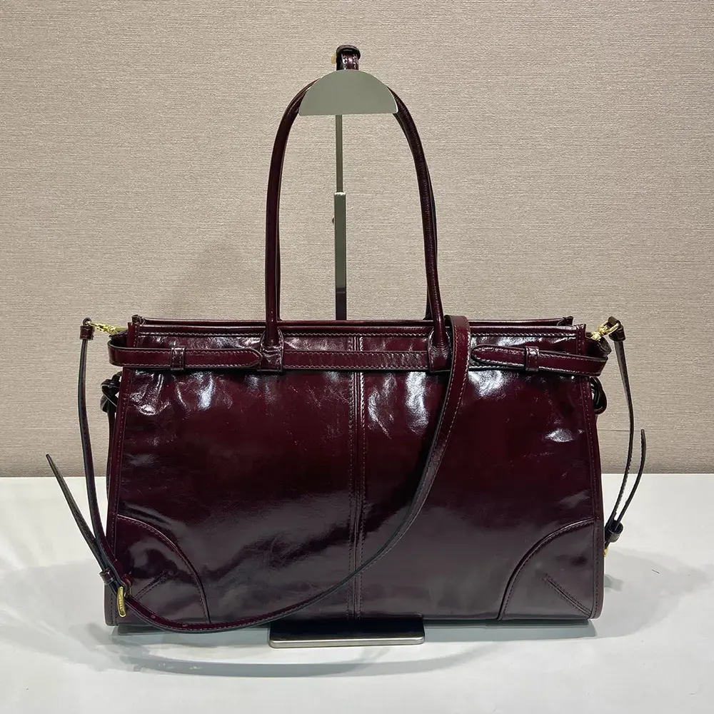 Side angle showing structured silhouette of Prada Women Bonnie Medium Leather Handbag-Maroon