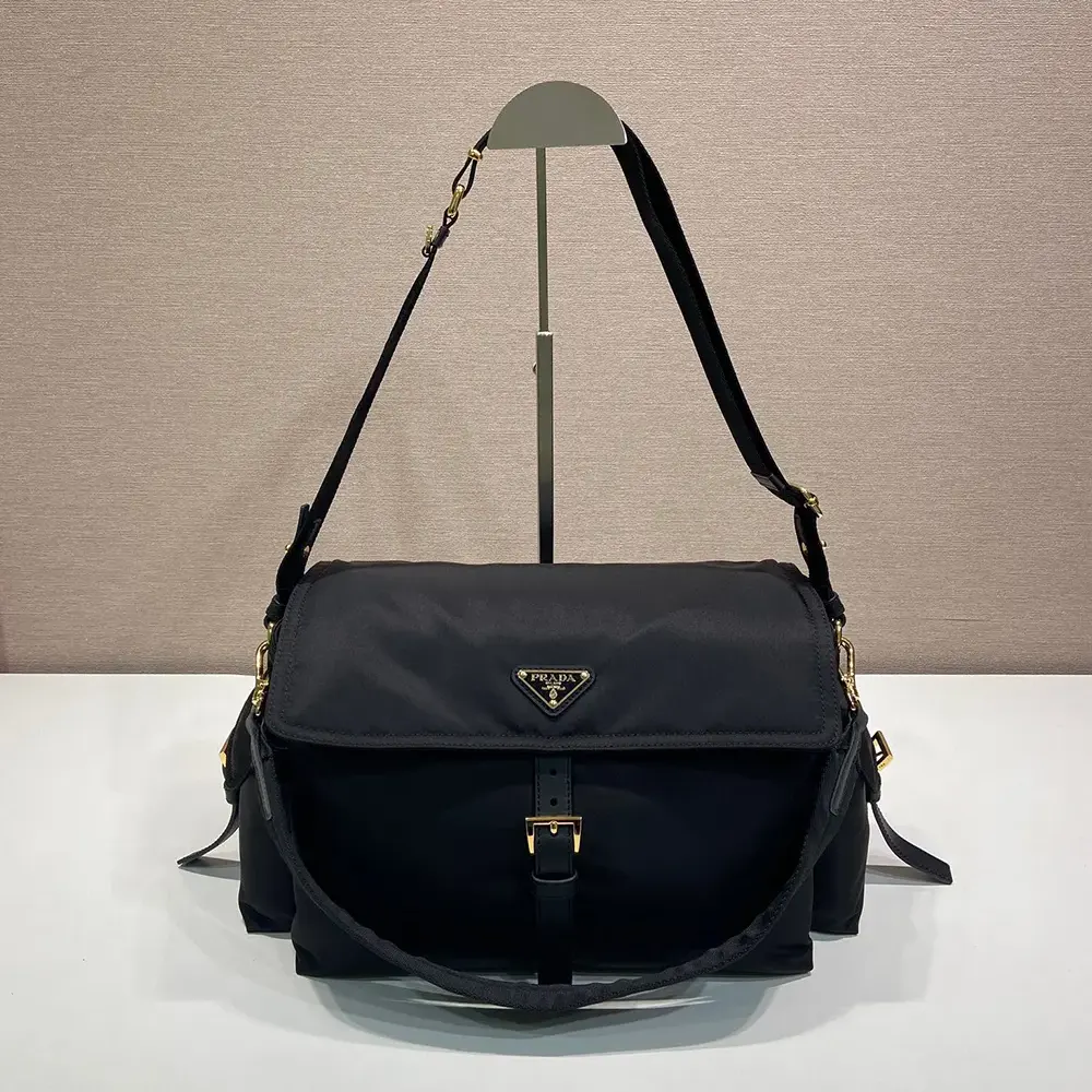 Close-up of Prada signature triangle logo on black Re-Nylon shoulder bag flap