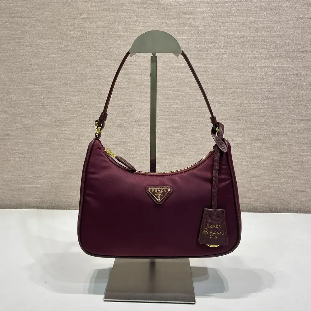 Close-up on gold-tone hardware and Prada logo plaque on Re-Nylon Mini Bag