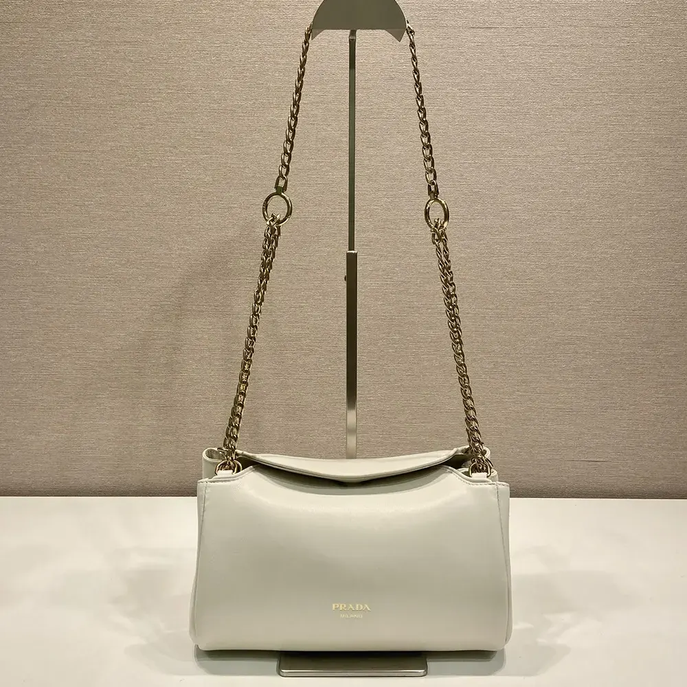 Close-up of silver-toned hardware on Prada Women Tumulte Small Nappa Leather Bag-White