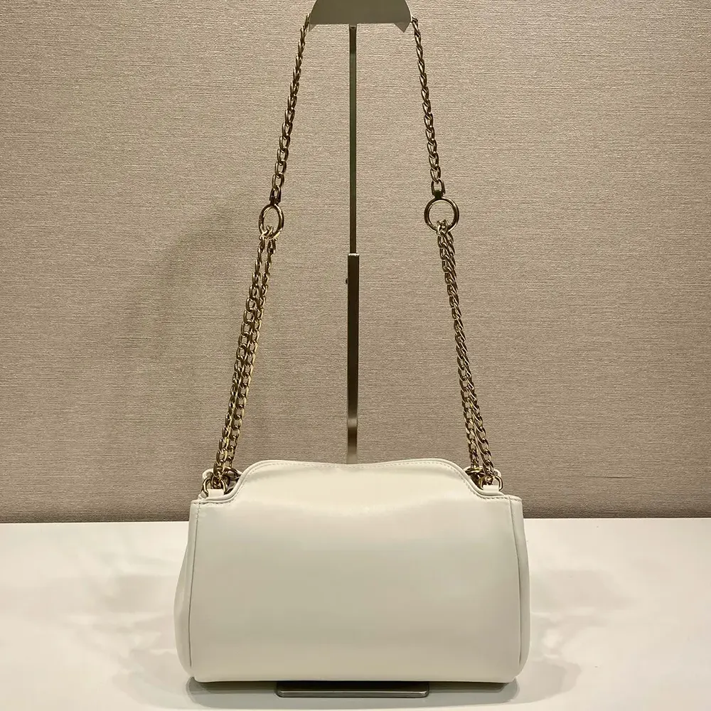 Side angle showing compact silhouette of Prada Women Tumulte Small Nappa Leather Bag-White