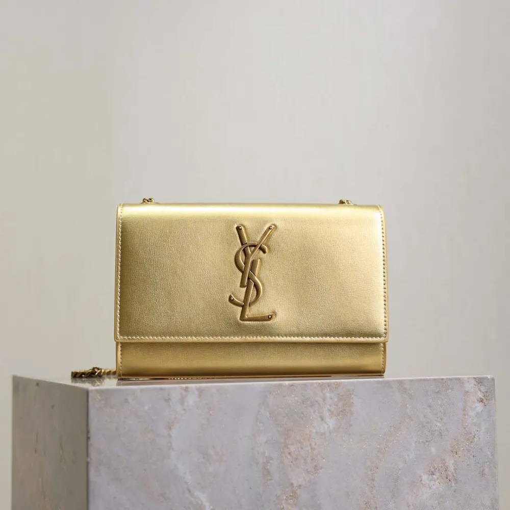 Close-up of gold-tone YSL logo on Kate Small metallic leather bag