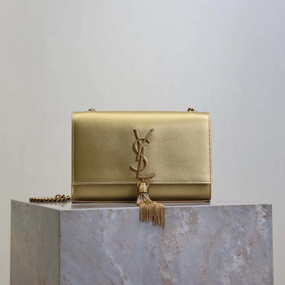 Close-up of gold YSL logo and leather tassel on the Saint Laurent bag