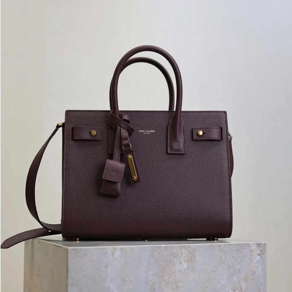 Close-up on gold-tone YSL hardware of Nano Sac De Jour maroon bag